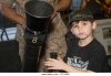 a-young-boy-examines-a-mortar-aboard-the-uss-iwo-jima-as-a-marine-cc7x6m.jpg